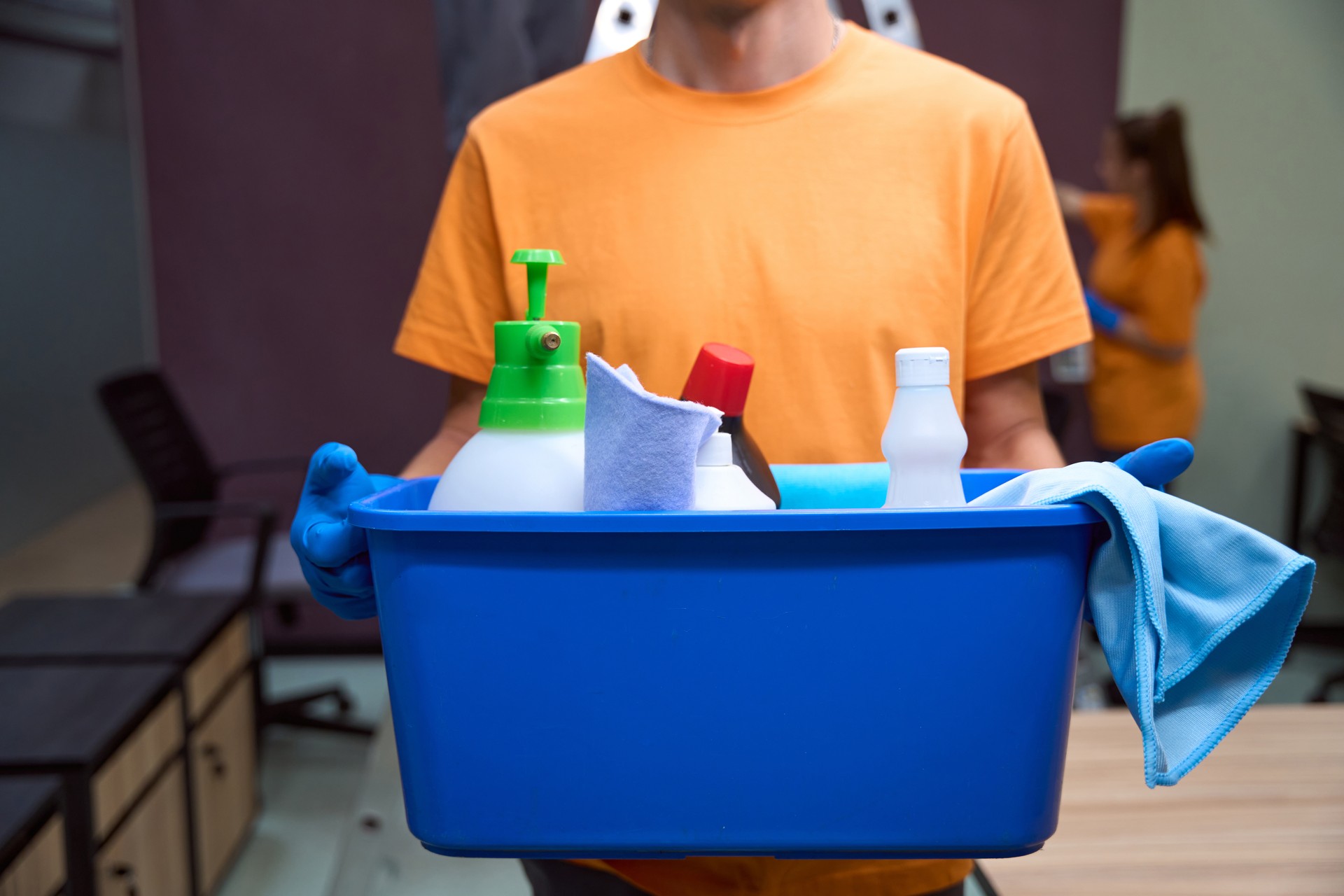 Unrecognised cleaning service worker standing with chemical equipment